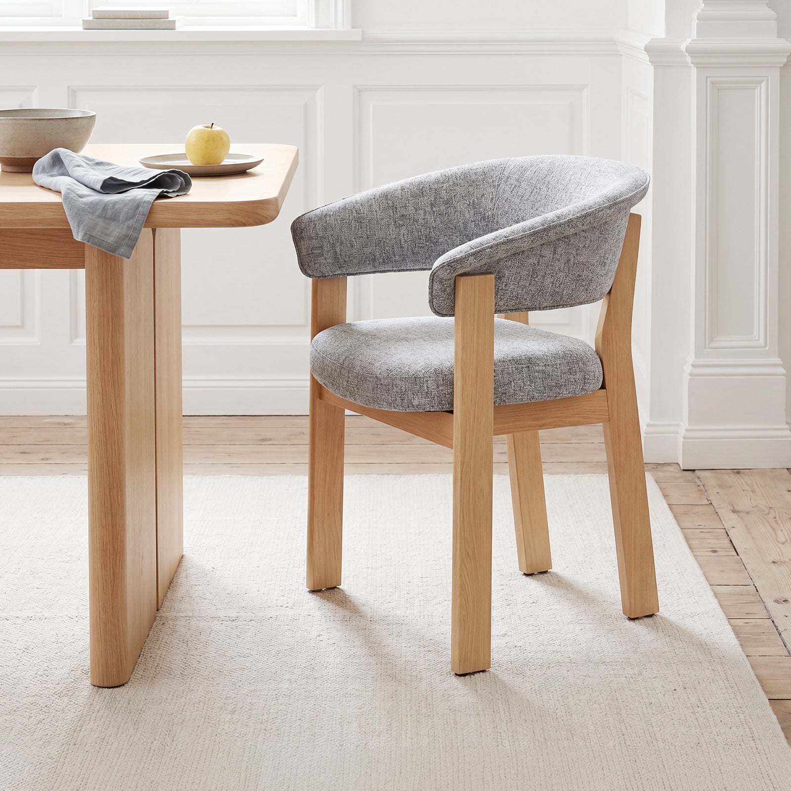 Light gray and natural oak HALO Luxe dining chair beside a wood table